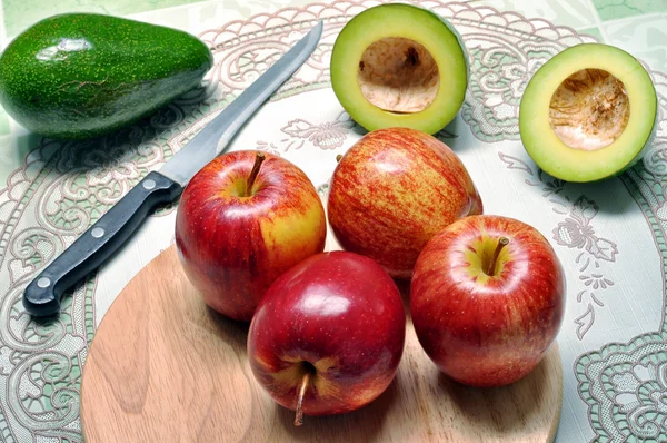 Vruchten van avocado en apple op de snijplank — Stockfoto