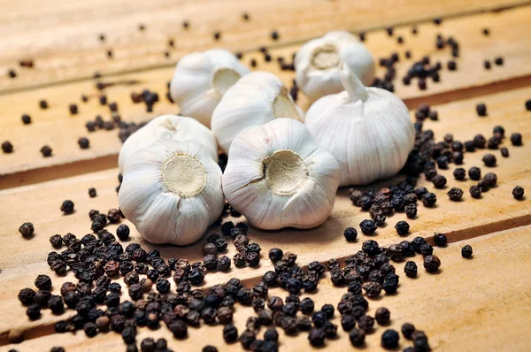 Knoflook en peper op een houten achtergrond — Stockfoto