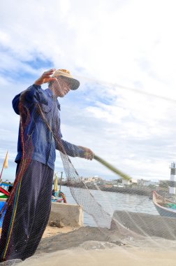 Quang Ngai, Vietnam - 31 Temmuz 2012: Bir balıkçı Hamsi balığı Ly oğlu adasında yeni bir iş günü başlayacak onun balık ağı üzerinden kaldırıyor