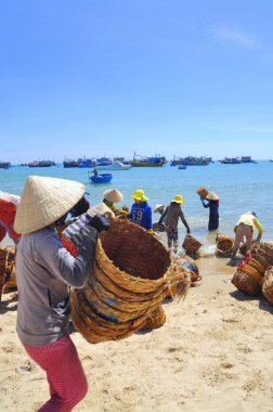 Lagi, Vietnam - 26 Şubat 2012: Yerel kadın kamyoneti tekne balıklara taşınmasında kullanılan kendi sepetleri temizlik yapıyorsun