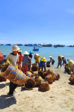 Lagi, Vietnam - 26 Şubat 2012: Yerel kadın kamyoneti tekne balıklara taşınmasında kullanılan kendi sepetleri temizlik yapıyorsun