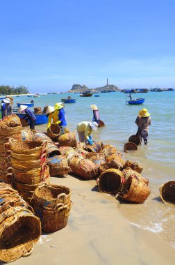 Lagi, Vietnam - 26 Şubat 2012: Yerel kadın kamyoneti tekne balıklara taşınmasında kullanılan kendi sepetleri temizlik yapıyorsun