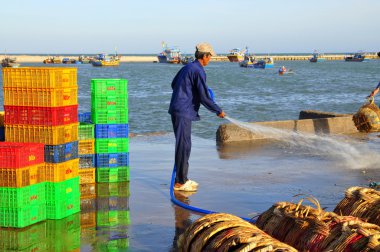 Lagi, Vietnam - 26 Şubat 2012: Yerel bir adam kamyona tekne balıklar taşınmasında kullanılan onun sepetleri temizliyor