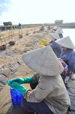 Ninh Hoa, Vietnam - 2 Mart 2012: Vietnam kadın tuz işçilerin tuz özü alanlardan depolama alanları için toplamak sıkı çalışmak sonra rahatlatıcı