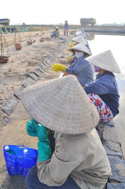 Ninh Hoa, Vietnam - 2 Mart 2012: Vietnam kadın tuz işçilerin tuz özü alanlardan depolama alanları için toplamak sıkı çalışmak sonra rahatlatıcı