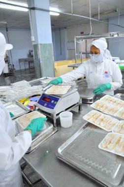 Ho Chi Minh city, Vietnam - October 3, 2011: Seafood finished products are prepared for weighing and vacuum packaging in a seafood factory in Vietnam