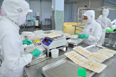 Ho Chi Minh city, Vietnam - October 3, 2011: Seafood finished products are prepared for weighing and vacuum packaging in a seafood factory in Vietnam