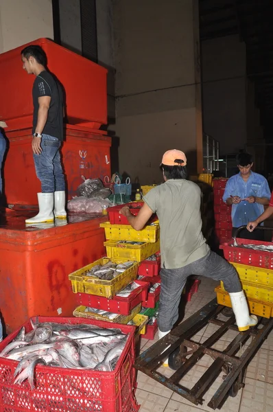 Ho Chi Minh City, Vietnam - November 28, 2013: Porters are working hard to load plenty baskets of fisheries at the Binh Dien wholesale night seafood market, the biggest one in Vietnam — Stock Photo, Image