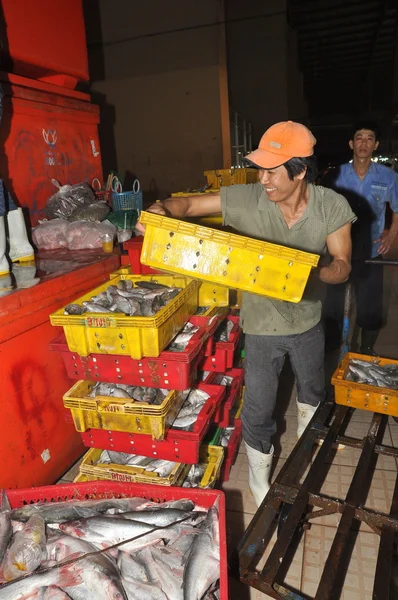 Ho Chi Minh City, Vietnam - November 28, 2013: Porters are working hard to load plenty baskets of fisheries at the Binh Dien wholesale night seafood market, the biggest one in Vietnam — Stock Photo, Image