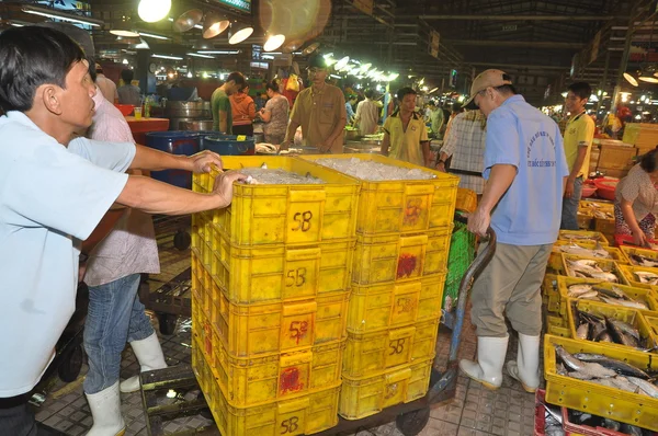 Ho Chi Minh City, Vietnam - 28 de noviembre de 2013: Los porteros están trabajando duro para cargar muchas cestas de pesca en el mercado de mariscos nocturnos al por mayor Binh Dien, el más grande de Vietnam — Foto de Stock