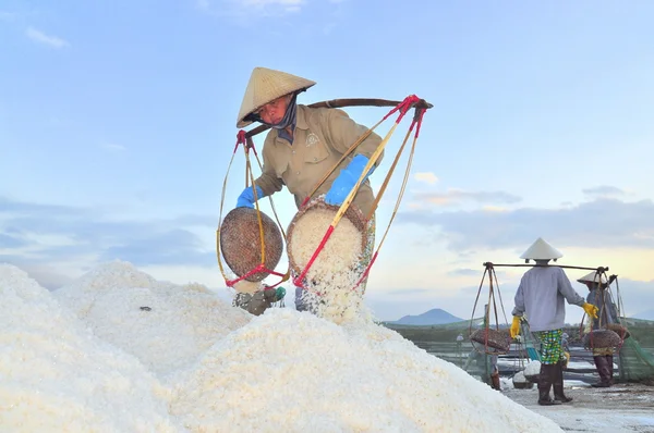 Ninh Hoa, Vietnam - 2 marzo 2012: Le donne vietnamite stanno gravando duramente per raccogliere il sale dai campi di estrazione ai campi di stoccaggio — Foto Stock