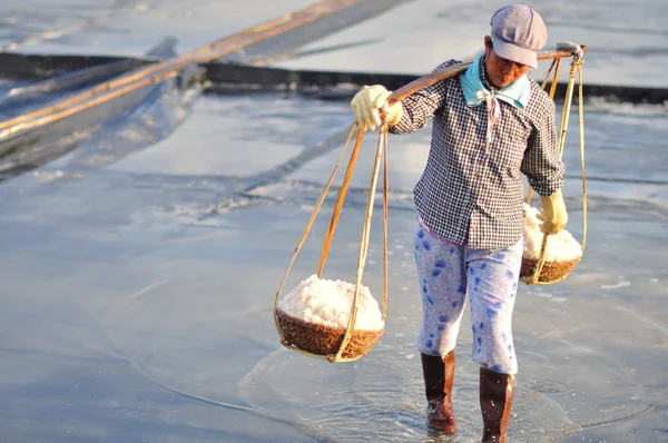 Ninh Hoa, Vietnam - 2 marzo 2012: Le donne vietnamite stanno gravando duramente per raccogliere il sale dai campi di estrazione ai campi di stoccaggio — Foto Stock