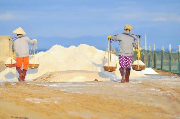 Ninh Hoa, Vietnam - 2 marzo 2012: Le donne vietnamite stanno gravando duramente per raccogliere il sale dai campi di estrazione ai campi di stoccaggio — Foto Stock