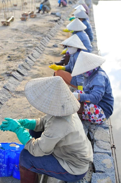 Ninh Hoa, Vietnã - 2 de março de 2012: Mulheres vietnamitas salinas estão relaxando depois de trabalhar duro para coletar sal dos campos de extração para os campos de armazenamento — Fotografia de Stock