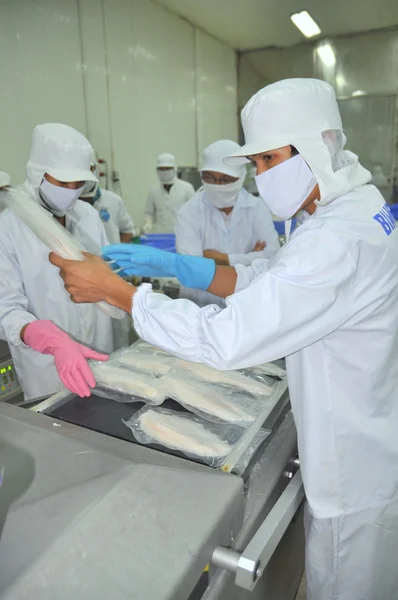 Can Tho, Vietnam - 1 de julio de 2011: Los trabajadores envasan al vacío bagre de pangasio en una fábrica de mariscos en el delta del Mekong de Vietnam — Foto de Stock