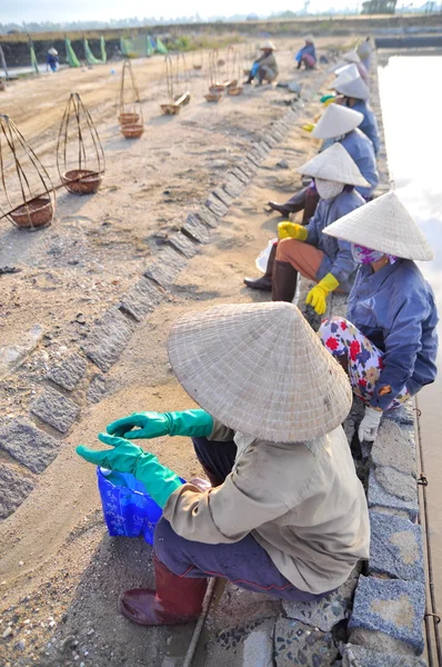 Ninh Hoa, Vietnam - March 2, 2012: Vietnamese women salt workers are relaxing after working hard to collect salt from the extract fields to the storage fields — Stock Photo, Image