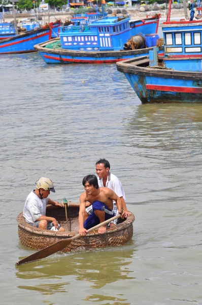 Nha Trang, Vietnam - October 5, 2011: Fishermen are swimming from their vessels to the seaport in a basket boat — Stockfoto