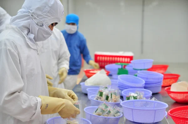 Vung Tau, Vietnã - 9 de dezembro de 2014: Trabalhadores são produtos de embalagem para exportação em uma fábrica de frutos do mar no Vietnã — Fotografia de Stock