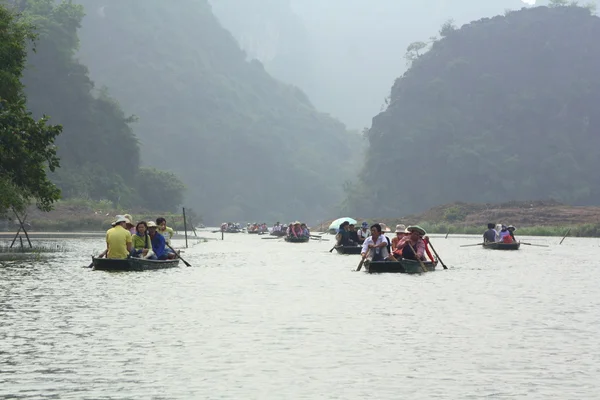 Ninh Binh, Vietnam - 29 de marzo de 2010: Ferrymen lleva a los turistas a visitar el Complejo Trang An Eco-Tourism, una belleza compleja - paisajes llamados como un museo geológico al aire libre —  Fotos de Stock