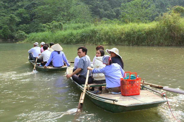 Ninh Binh, Vietnam - March 29, 2010: Ferrymen are taking tourists to visit the Trang An Eco-Tourism Complex, a complex beauty - landscapes called as an outdoor geological museum — Stock Photo, Image