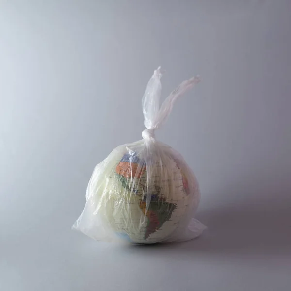 Plastik bir poşet içinde Dünya gezegeni. Asgari çevre kavramı.
