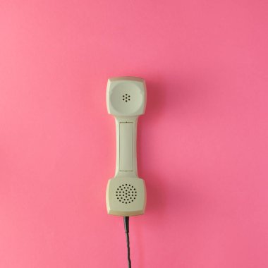 Pembe arka planda gri bir telefon tüpü var. Düz yatıyordu 