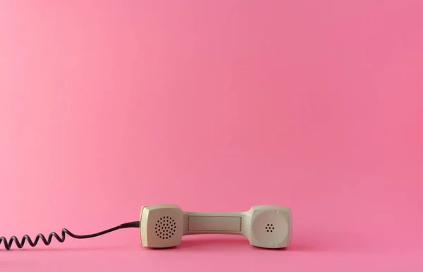 Pembe arka planda gri bir telefon tüpü var. Yaratıcı kopyalama alanı