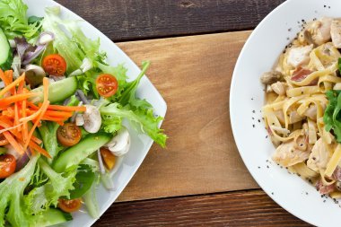 Pasta tavuk ve sebze salatası yemek masada