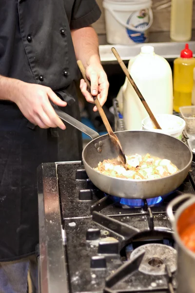 Şef gaz alev üzerinde pasta tavuk pişirme