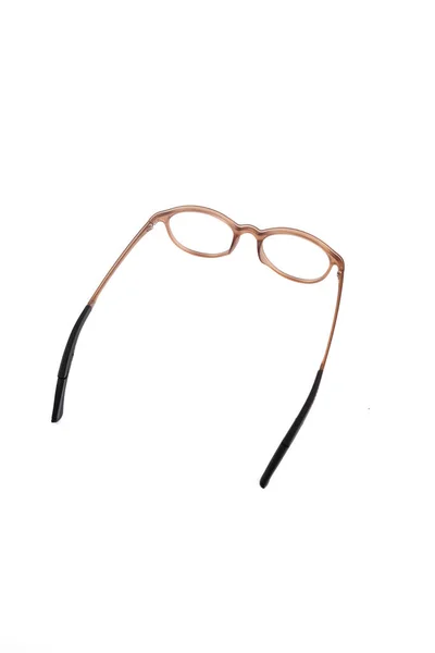 白い背景の隔離ガラス 褐色の耳のロックが付いた丸いメガネフレーム 白い背景の上からの写真のメガネは — ストック写真