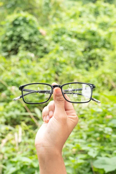 Handgehaltene Schwarz Glänzende Quadratische Gläser Vor Dem Hintergrund Sanfter Hügel — Stockfoto