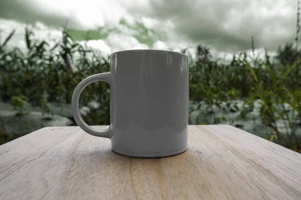 目の前にマグカップとコーンファームビュー 自然景観を背景にしたマグカップモックアップ — ストック写真