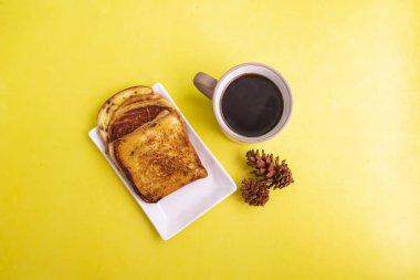 Beyaz tabakta tost ve arka planda ladin çiçekli sade kahve kupası. Kahvaltıda tost ve sade kahve. Yatay Resim