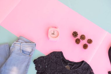 Kadın giysisinin temel düzeni, soluk nane arkaplanlı siyah bluz. Yaşam tarzı konsepti. Çalar saat. Küçük çanta. ba