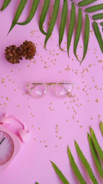 Resimde oval gözlük var. Pastel pembe arka planda yaz tarzında..