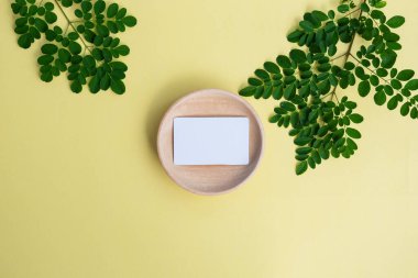 Pastel sarısı arka planda doğal stili olan tahtadaki kartvizit. minimalist styl