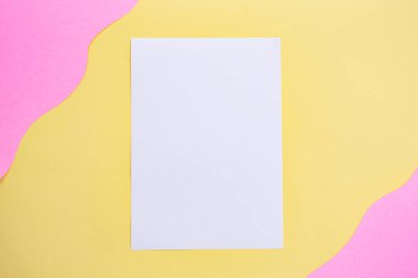Sarı ve pembe arkaplan üzerine beyaz kağıt. minimalist styl