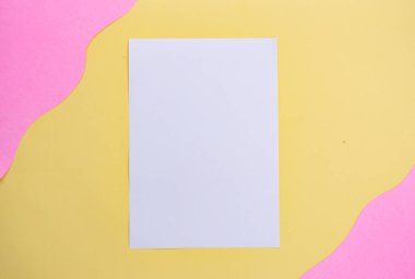 Sarı ve pembe arkaplan üzerine beyaz kağıt. minimalist styl