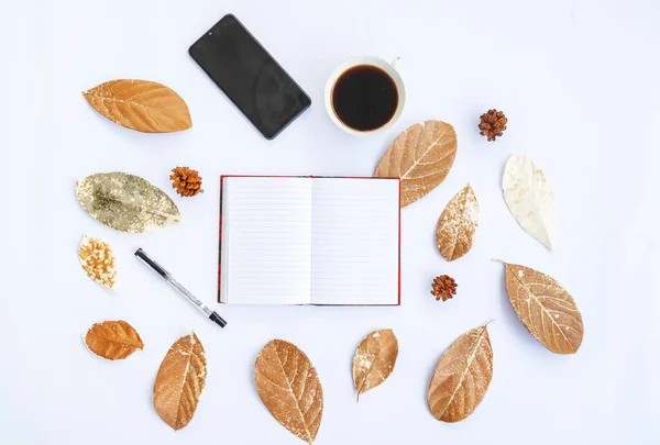 Minimalist Concept. dry leaves, book and pen, pine tree flower, mobile phone on white background. Autumn, autumn concept. Flat lay, top view, copy spac
