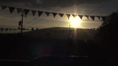 Flamalar, gün batımı ve köydeki dağlar.