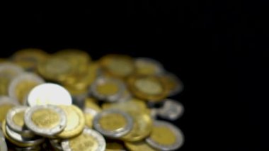 Siyah arka planı olan bir sürü Meksika sikkesi