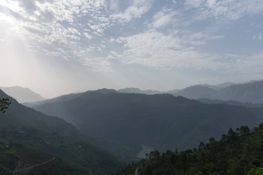Güneş ışığı ve dağ zirveleriyle vadideki nefes kesici manzara.