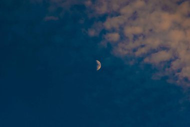 Güzel Günbatımı ve Muhteşem Ay beyaz gökyüzü ve turuncu arka planla yükseliyor.