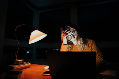 Kafkasyalı stresli öğrenci son teslim tarihine kadar el ele tutuşup gece geç saatlere kadar dizüstü bilgisayarla çalışıyor.