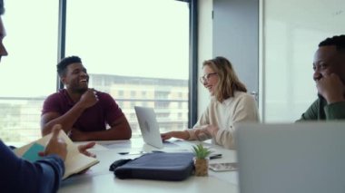 Kafkas iş adamları grubu dizüstü bilgisayarları kullanarak ve kağıt işlerini okuyarak yeni projeyi tartışıyor.