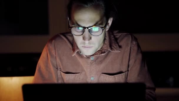 Caucásico macho lanza libre trabajador trabajando hasta tarde en la noche escribiendo en el ordenador portátil en apartamento — Vídeos de Stock
