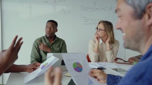 Colegas de negócios conversando sobre números e figuras enquanto se envolvem em reunião sentados na sala de bordo — Vídeo de Stock