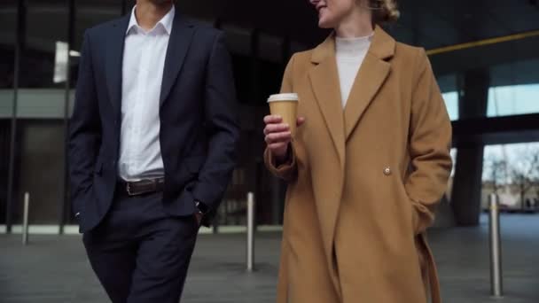 Gemengde race zakenman en blanke vrouw collega 's lopen door straat drinken van koffie voor zakelijke bijeenkomst — Stockvideo