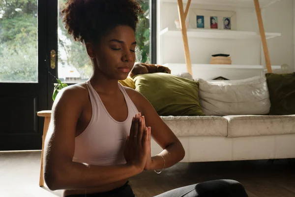 Vrouwelijke tiener met bidpositie tijdens de yogaflow zittend in de moderne lounge — Stockfoto