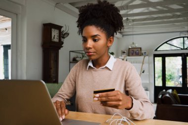 Kilit altında çevrimiçi alışveriş yaparken evde kredi kartı ödemesi yapan kadın